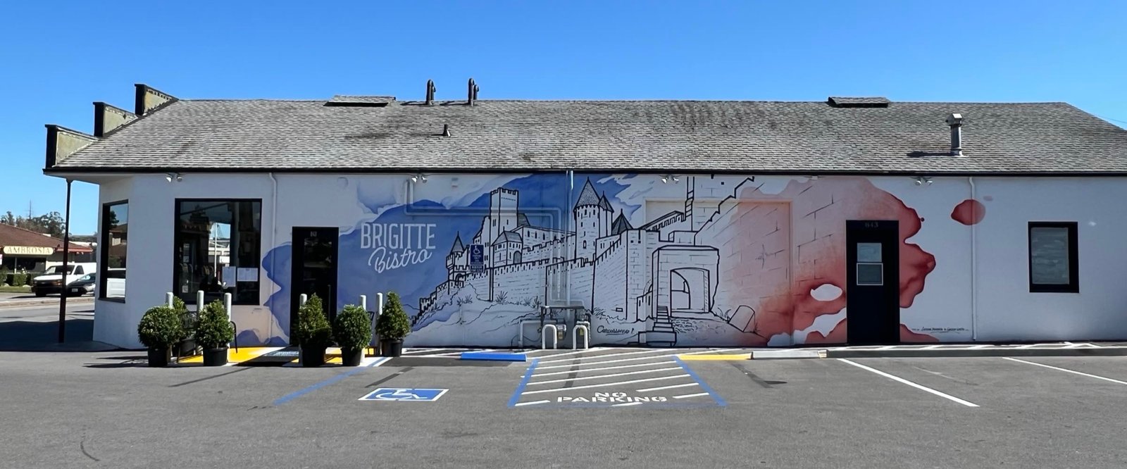 Brigitte Bistro building with the blue Carcassonne mural and the Brigitte Bistro logo painted on the side